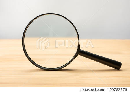 Magnifying glass black color on wooden table. Research, searching or investigating something. front view Magnifying glass 90782776
