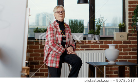 Portrait of elder teacher training art students to draw artistic sketch, sitting in creative workshop class. Personal development activity to teach drawing technique and vision with instruments. Portrait of elder teacher training art students to draw artistic sketch, sitting in creative workshop class. Personal development activity to teach drawing technique and vision with instruments. 90783517