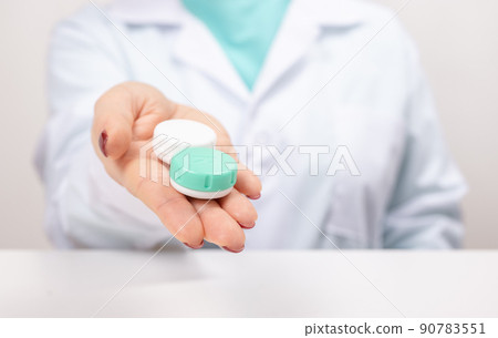 Doctor holds in his hand container with soft contact lenses for reusable use. Ophthalmologist prescribes use of contact lenses for Eyesight correction. Myopia and eyesight problem concept. 90783551