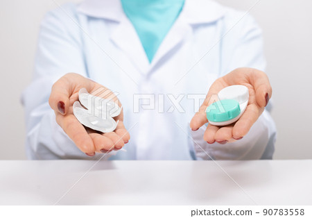 Doctor Ophthalmologist holding in hands one-day contact lenses and reusable contact lenses. choosing between types of contact lenses . myopia and eyesight problem concept 90783558