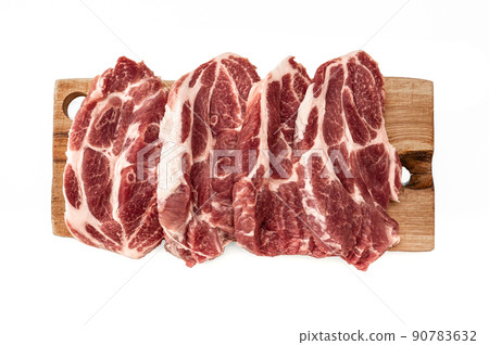 Top view of raw pork steaks in row on wooden board. Pork steaks on cutting board. isolated on white background. Raw meat on a wooden cutting board. Top view of raw pork steaks in row on wooden board. Pork steaks on cutting board. isolated on white background. Raw meat on a wooden cutting board. 90783632