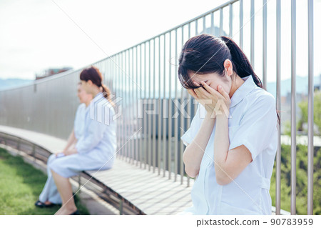 Female nurse crying on the roof of the hospital 90783959