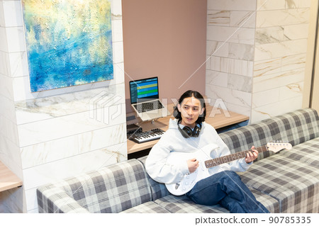 Young man playing white electric guitar 90785335
