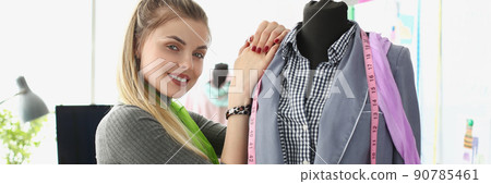 Woman seamstress posing near brand new jacket and being proud of it 90785461