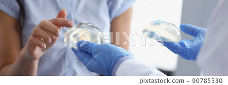 Woman client touch silicone breast implant from doctors hand 90785530