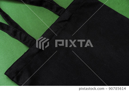 Textile shopping bag on green background flat lay Textile shopping bag on green background flat lay 90785614