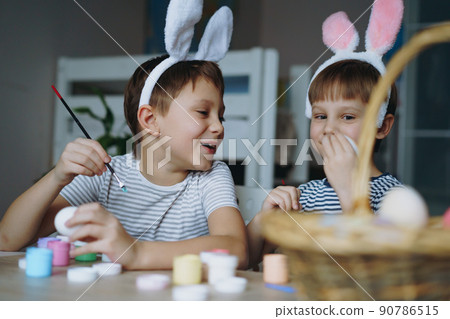 Cute little boys colouring eggs for easter Cute little boys colouring eggs for easter 90786515