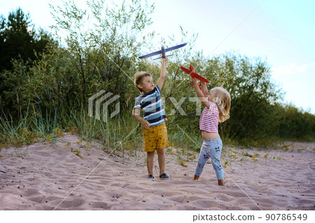 caucasian little children holding toy planes in hands 90786549