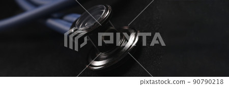 Head of medical stethoscope lying on black background closeup Head of medical stethoscope lying on black background closeup 90790218