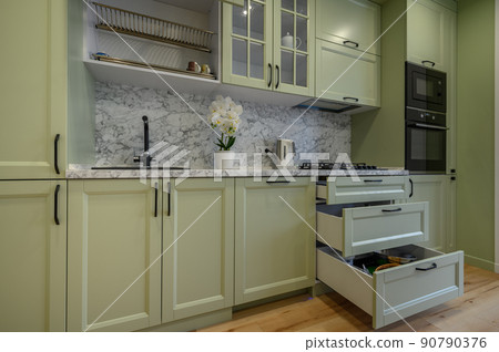 Modern light green luxurious kitchen with dining table 90790376