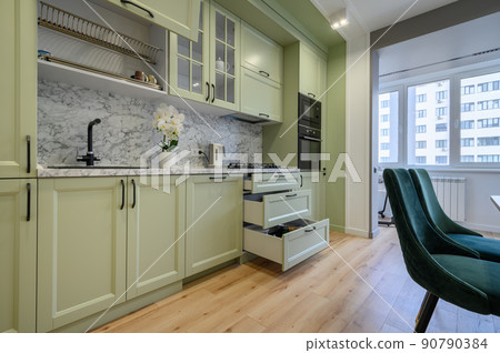 Modern light green luxurious kitchen with dining table 90790384