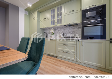 Modern light green luxurious kitchen with dining table Modern light green luxurious kitchen with dining table 90790422