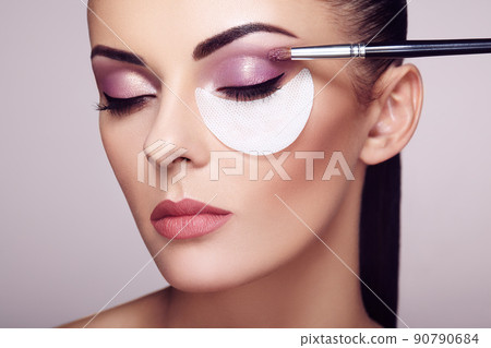 Makeup artist applies eye shadow 90790684