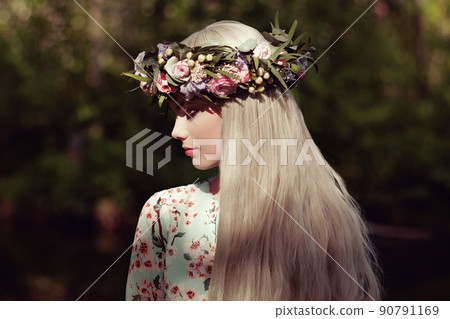Beautiful blonde woman with flower wreath on her head 90791169