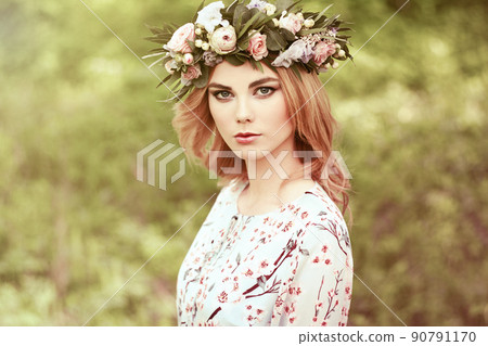 Beautiful blonde woman with flower wreath on her head Beautiful blonde woman with flower wreath on her head 90791170