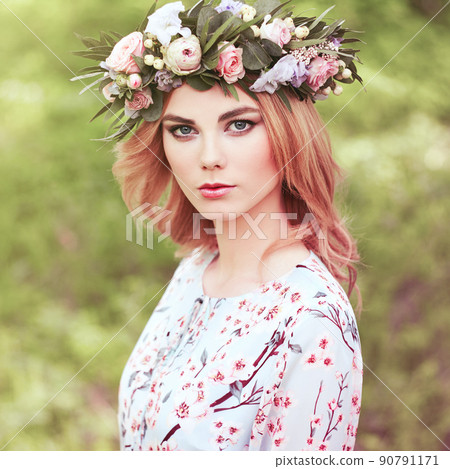 Beautiful blonde woman with flower wreath on her head Beautiful blonde woman with flower wreath on her head 90791171