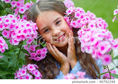 Adorable little girl in pink flowers phlox Adorable little girl in pink flowers phlox 90792298