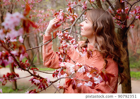 Beautiful woman standing under pink blossom Sakura Beautiful woman standing under pink blossom Sakura 90792351