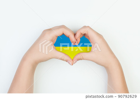 Heart with flag of Ukraine in female hands on white background 90792629