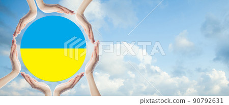 Human hands protect flag of Ukraine on blue sky with white clouds background 90792631
