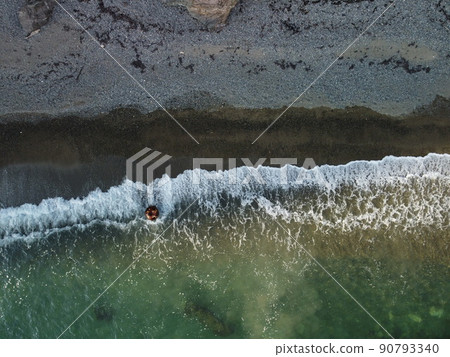 Aerial view from above on calm azure sea and volcanic rocky shores. Small waves on water surface in motion blur. Nature summer ocean sea beach background. Nobody. Holiday, vacation and travel concept Aerial view from above on calm azure sea and volcanic rocky shores. Small waves on water surface in motion blur. Nature summer ocean sea beach background. Nobody. Holiday, vacation and travel concept 90793340