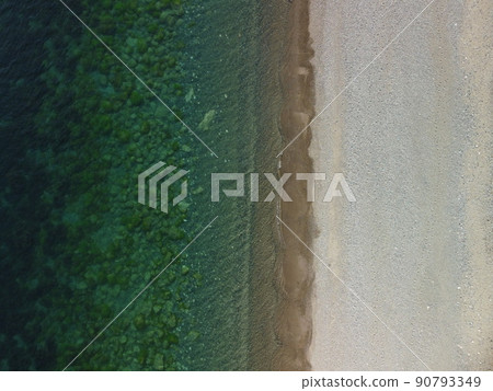 Aerial view on calm azure sea and volcanic rocky shores. Small waves on water surface in motion blur. Nature summer ocean sea beach background. Nobody. Holiday, vacation and travel concept Aerial view on calm azure sea and volcanic rocky shores. Small waves on water surface in motion blur. Nature summer ocean sea beach background. Nobody. Holiday, vacation and travel concept 90793349