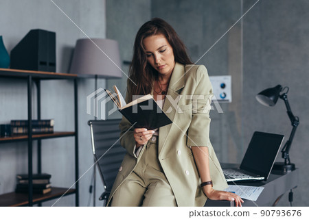 Woman in the office looks in her notebook 90793676