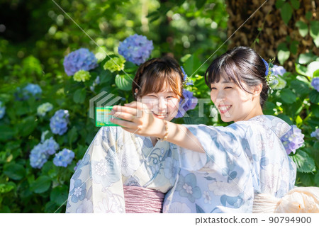 一位年輕女子在繡球花前用一次性相機自拍 90794900