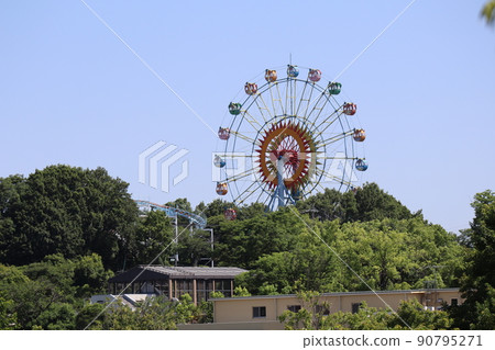 藍天綠樹公園中帶摩天輪的遊樂園風景 90795271