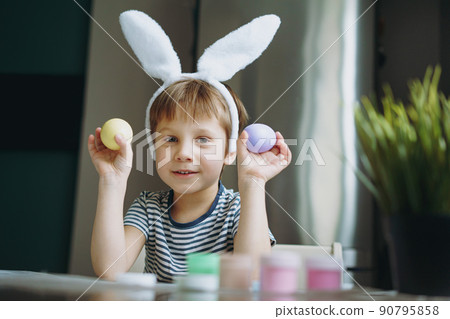 Cute little boy colouring eggs for easter 90795858