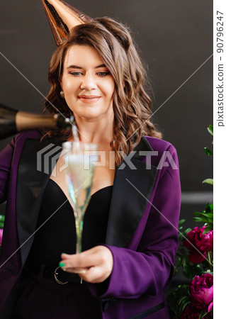a brunette woman with a glass and a bottle of champagne  a brunette woman with a glass and a bottle of champagne  90796247