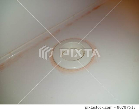 Red mold stains around the drain button of the bath 90797515