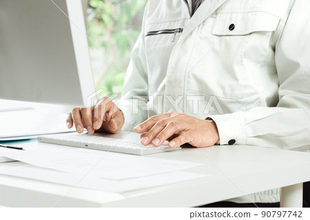 一個穿著工作服在電腦上工作的男人的手 一個穿著工作服在電腦上工作的男人的手 90797742
