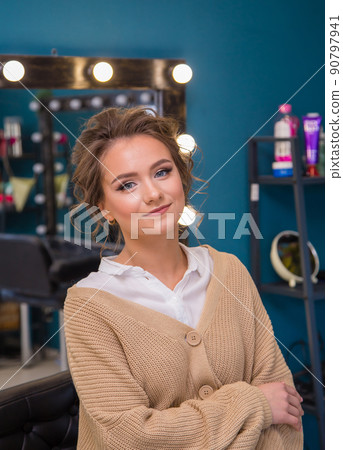 Girl with fashionable make-up and hairstyle smiling while looking at the camera. Girl with fashionable make-up and hairstyle smiling while looking at the camera. 90797941