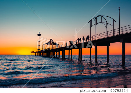 Iconic Brighton jetty with people silhouettes at sunset 90798324