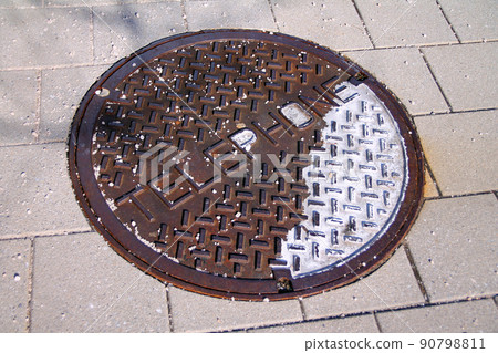 An old oxidized telephone manhole on a public walkaway 90798811