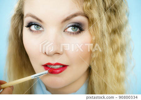 Applying lipstick on fashion model lips 90800334