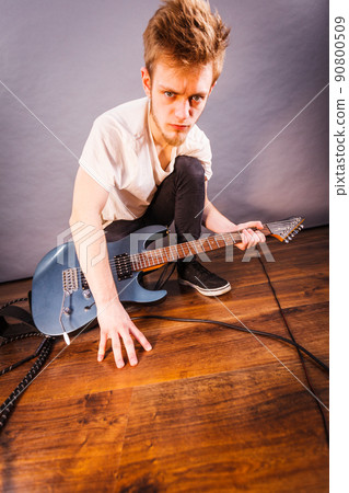 Man setting up guitar equipment Man setting up guitar equipment 90800509