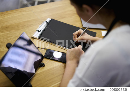 Cropped image of female barista making commercial and retail report on black pages Cropped image of female barista making commercial and retail report on black pages 90800886