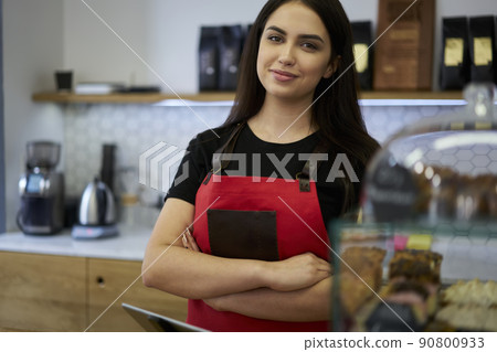 Positive prosperous woman waiter looking at camera near bar 90800933
