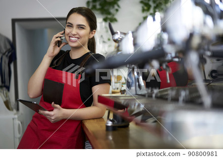 Prosperous female owner of coffee house calling to operator making order for retail business Prosperous female owner of coffee house calling to operator making order for retail business 90800981