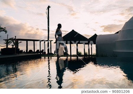 Unrecognizable woman standing at sunset 90801206