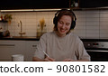 Beautiful girl in headphones listens to music, rejoices and uses a laptop in the living room 90801582
