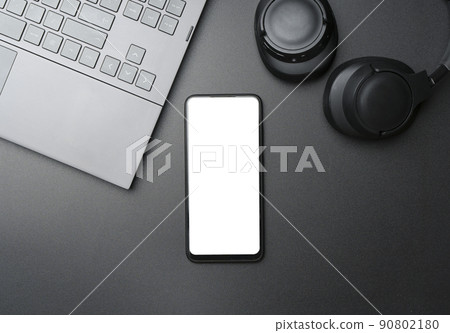 Headphones with smartphone with blank screen on black background. Music app, listening to audio, podcast concept. 90802180