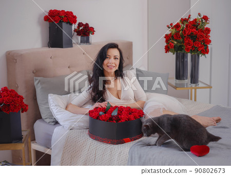 young woman in white dres is sitting on bed. young woman in white dres is sitting on bed. 90802673