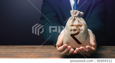 Businessman holds out indian rupee money bag. Getting a grant. Easy Money. Salary, benefits, profit. Attracting investments. Deposit savings. Cashback. Banking and crediting. Mortgage, loan approval. Businessman holds out indian rupee money bag. Getting a grant. Easy Money. Salary, benefits, profit. Attracting investments. Deposit savings. Cashback. Banking and crediting. Mortgage, loan approval. 90804512