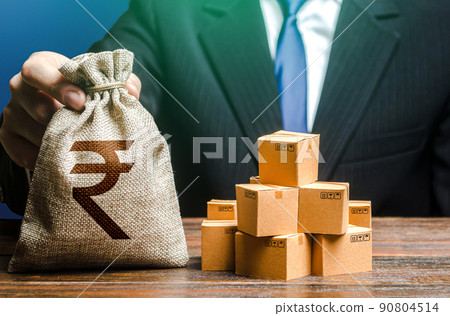 Businessman holds indian rupee money bag and boxes with goods. Import and export. Business income. Payment of taxes and fees. Advertising budget. Purchase and sale of goods, trade and commerce. Businessman holds indian rupee money bag and boxes with goods. Import and export. Business income. Payment of taxes and fees. Advertising budget. Purchase and sale of goods, trade and commerce. 90804514