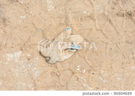 A thrown or forgotten construction glove and tractor tire marks. A thrown or forgotten construction glove and tractor tire marks. 90804689