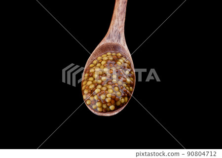 Wooden spoon full of french mustard isolated on black background. Wooden spoon full of french mustard isolated on black background. 90804712