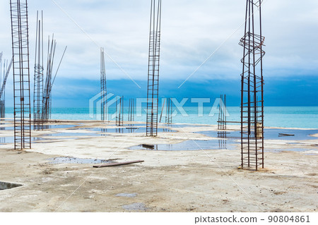 unfinished building with protruding rebar on the seashore unfinished building with protruding rebar on the seashore 90804861